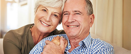Senior couple holding hands and smiling