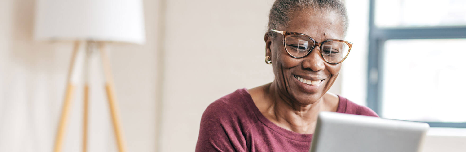 Senior African American woman smiling at tablet