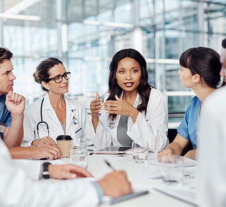 Photo of a group of doctors sitting around a table having a discussion