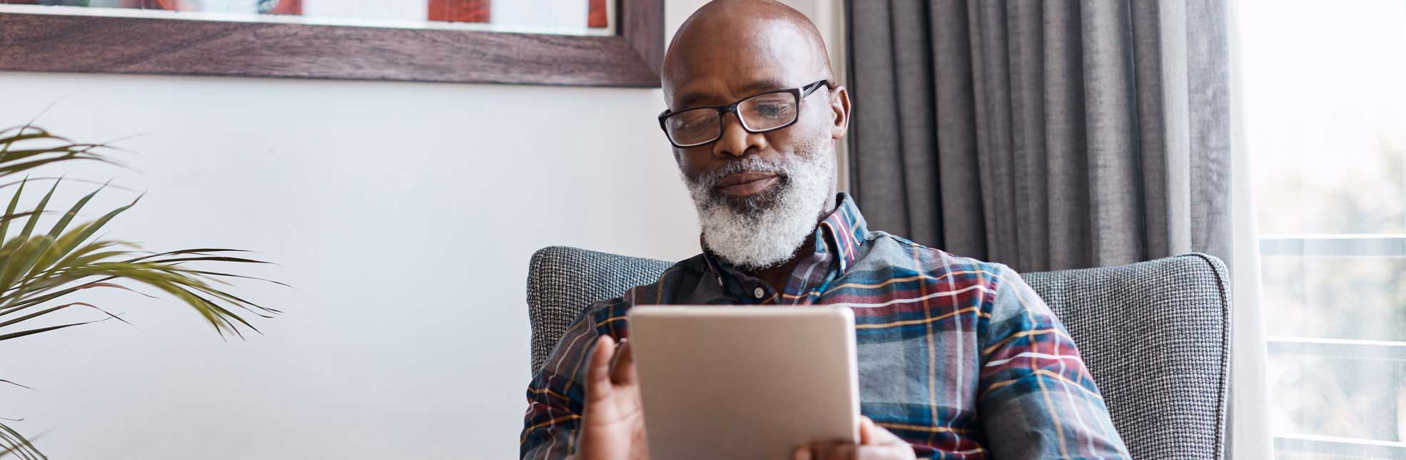 senior african american man holding digital tablet
