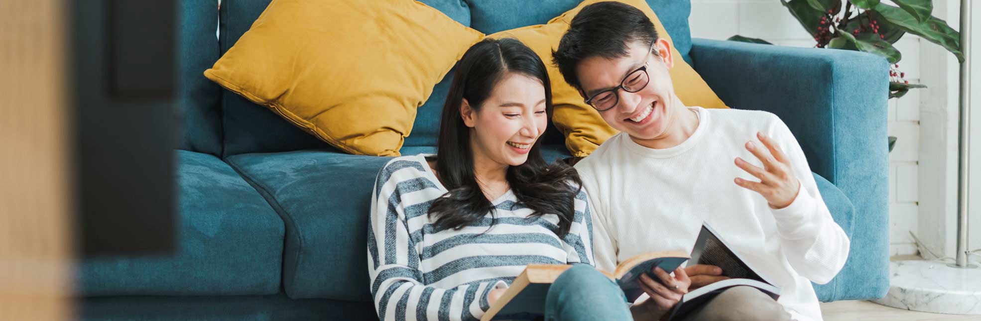 smiling young couple sitting on living room floor together
